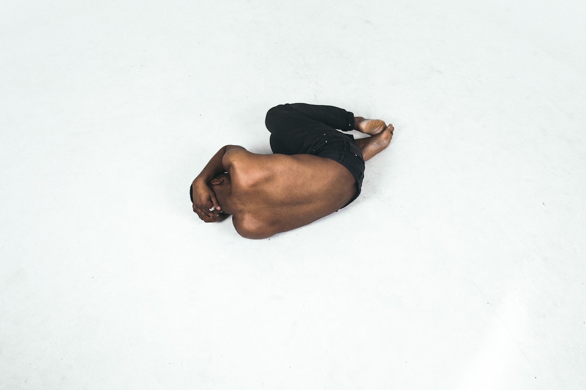 Homem encolhido no chão