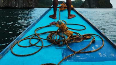 Homem em pé na proa de bote