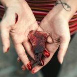 Mãos ensanguentadas com vidro quebrado